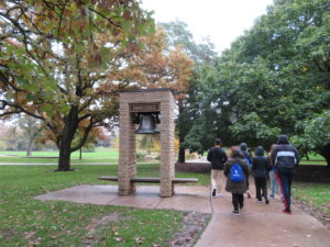 Students walking past Luther College bell