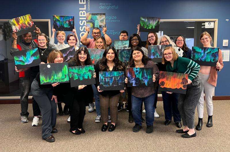 Photo Of AmeriCorps And Leadership Team Holding Paintings