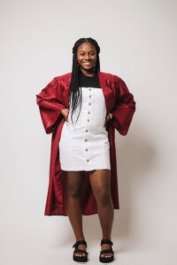 Woman high schooler posing in graduation gown
