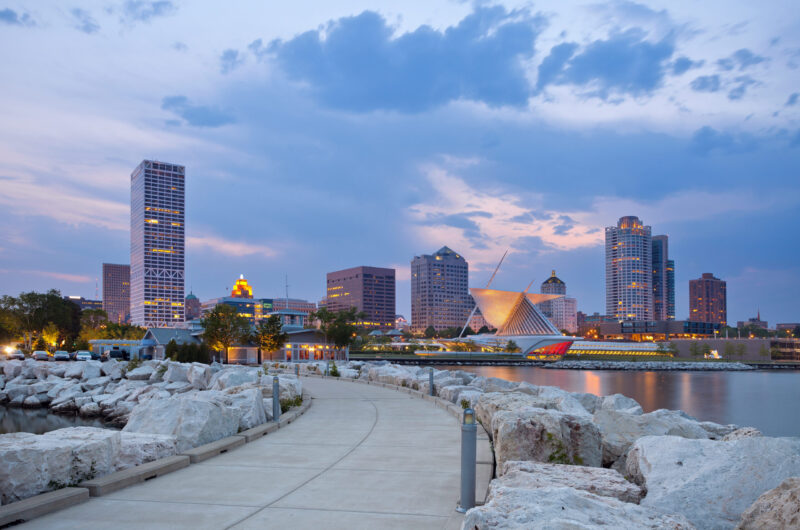 A Dusk View Of The Milwaukee Skyline Offers A View Of The Milwaukee Fine Arts Museum, The Lake Michigan Waterfront, And A Walking Path Lined With White Rocks.