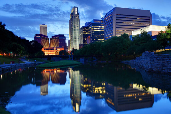 The Omaha Skyline Reflects On A Pond Luminated By The Dusk Sky.