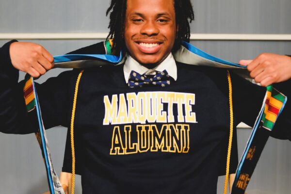 Rashad Proudly Displays Graduation Stoles Over A Marquette University Sweatshirt