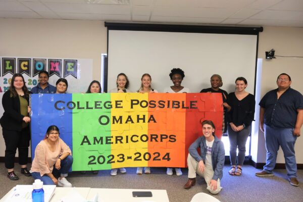 Group Photo Of 13 People Holding A Colorful Sign That Says College Possible Omaha AmeriCorps 2023-24