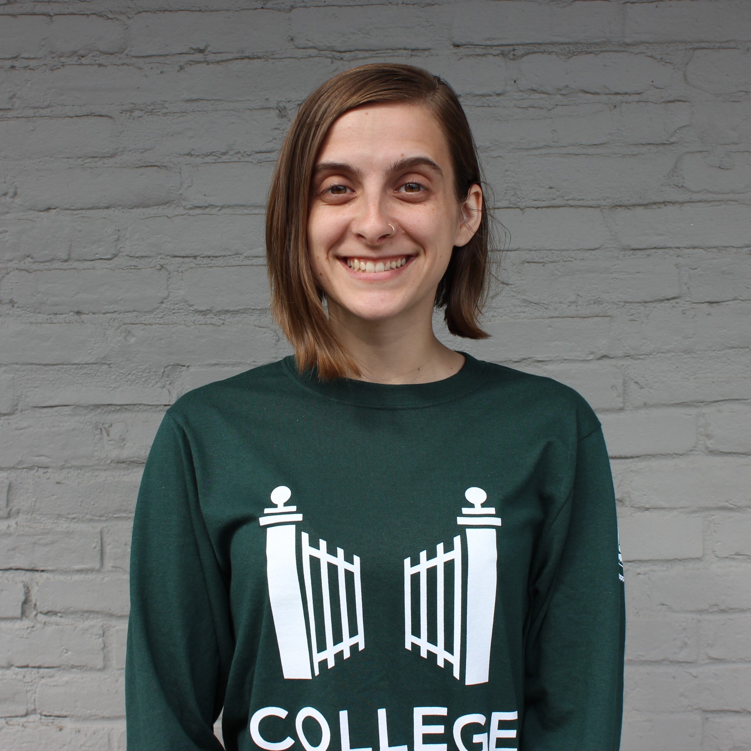 Person smiling towards the camera wearing a college possible shirt