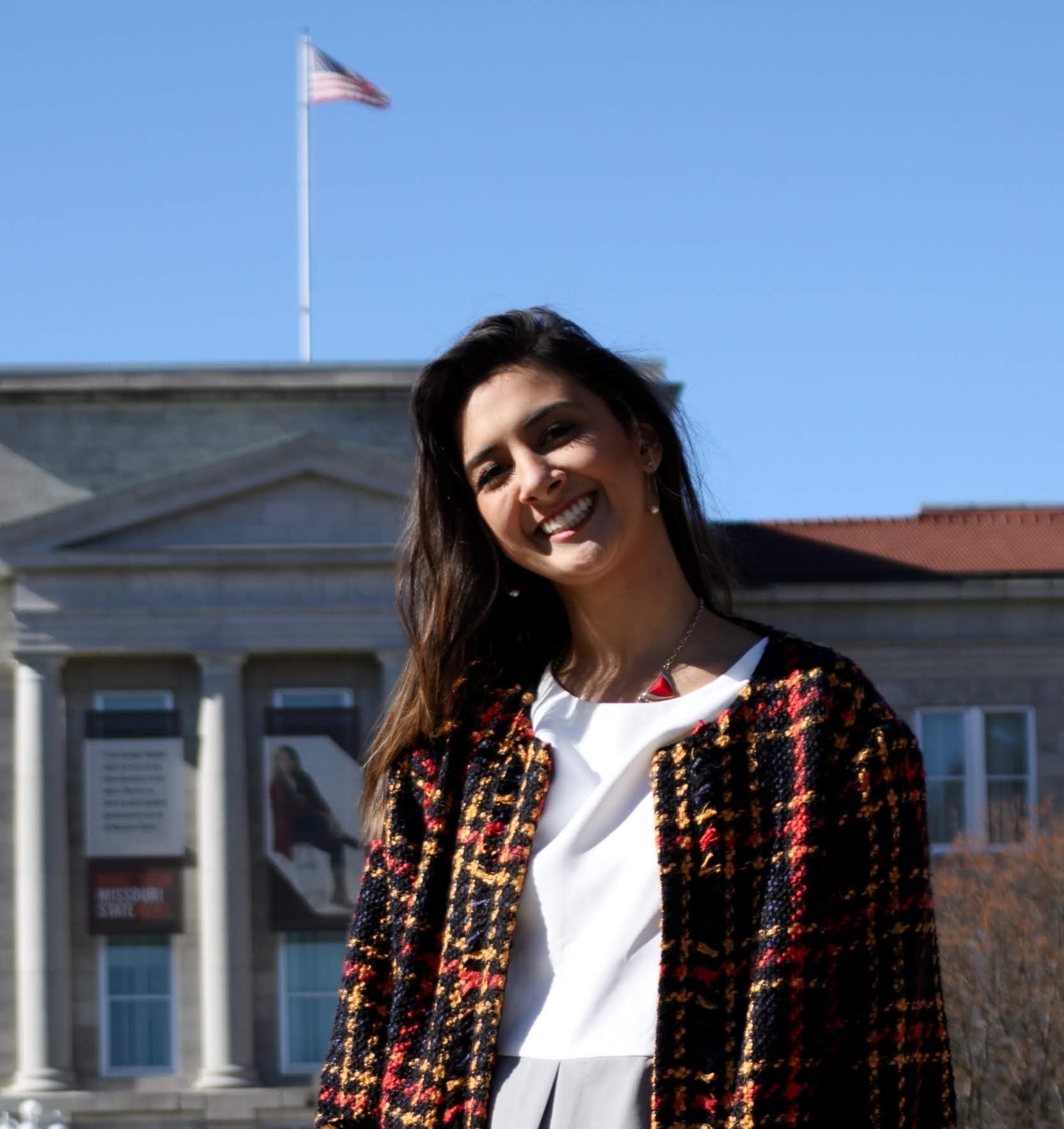 Woman smiling in front of academic building