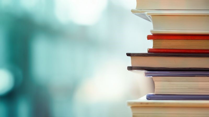 Photo Of A Stack Of Books With A Blue Background.