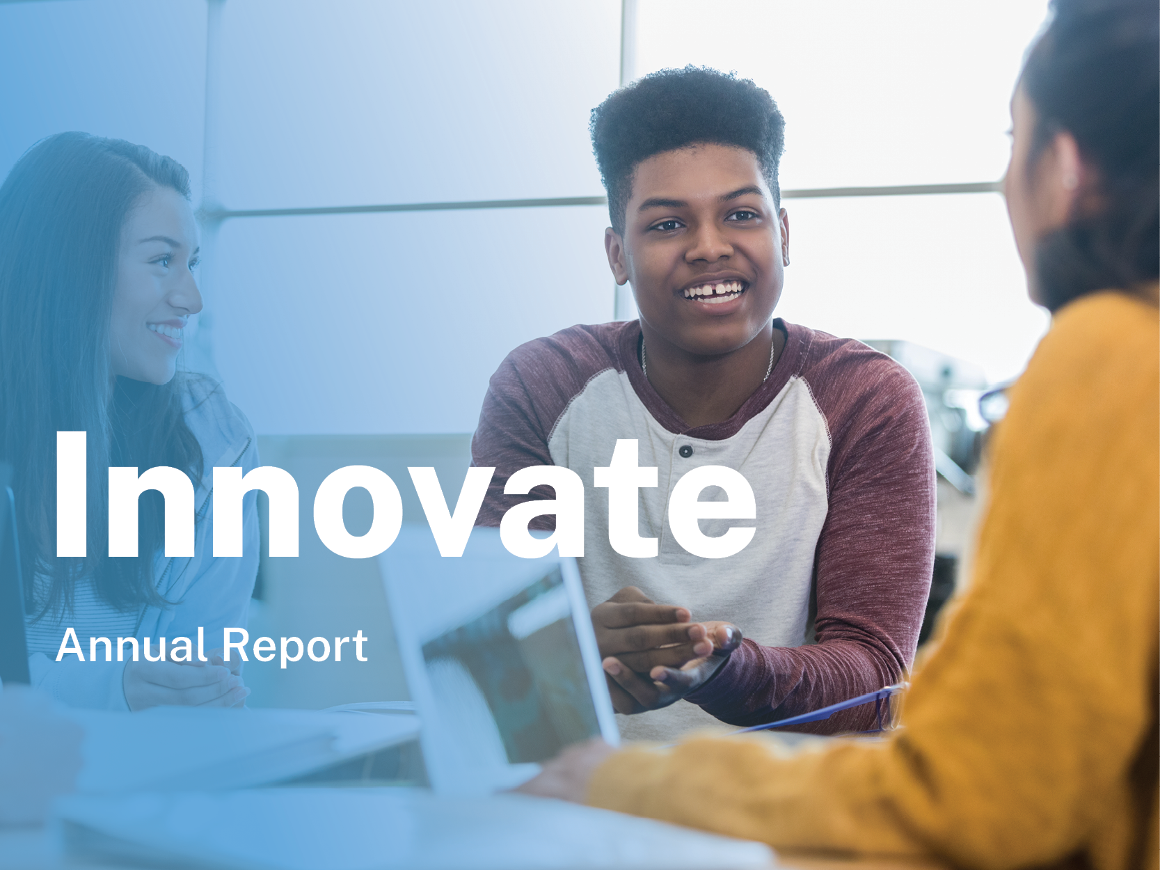 Group of multiethnic students studying at a table and smiling, with text that reads Innovate: Annual Report