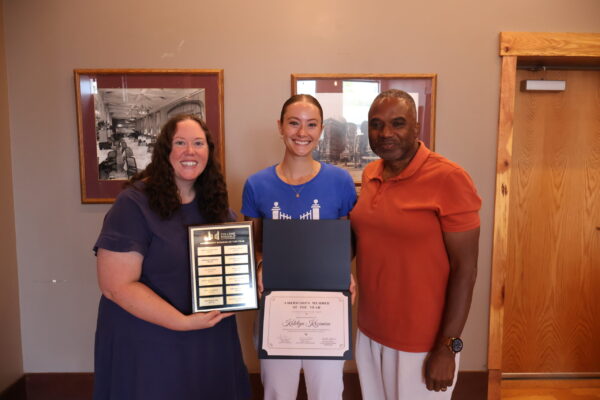 Katie Smiling, Holding Her Award With Supervisor Mallory On Her Left, And Senior Executive Director Arvin Frazier On Her Right.