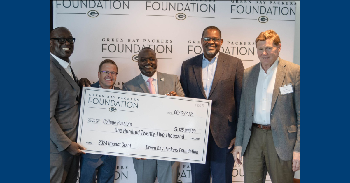 five men smiling holding a Green Bay Packers Foundation check