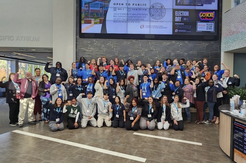 Group Photo Of AmeriCorps Members Serving In Nebraska Holding Their Arms Up In A Flexing Position, Smiling.