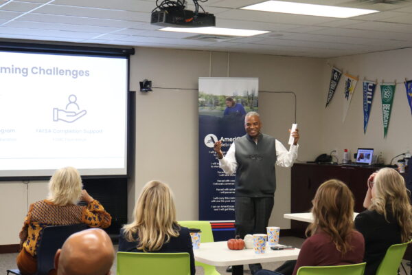 Senior Executive Director Arvin Frazier Smiling While Giving A Presentation At The Community Partners Open House.