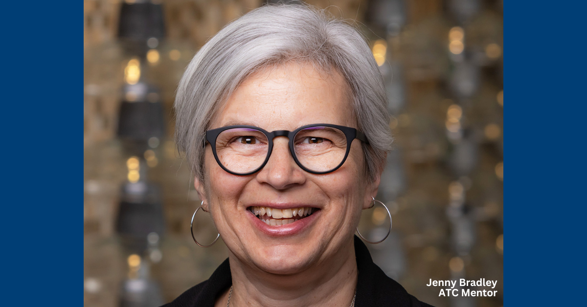 Woman with short gray hair and glasses smiling