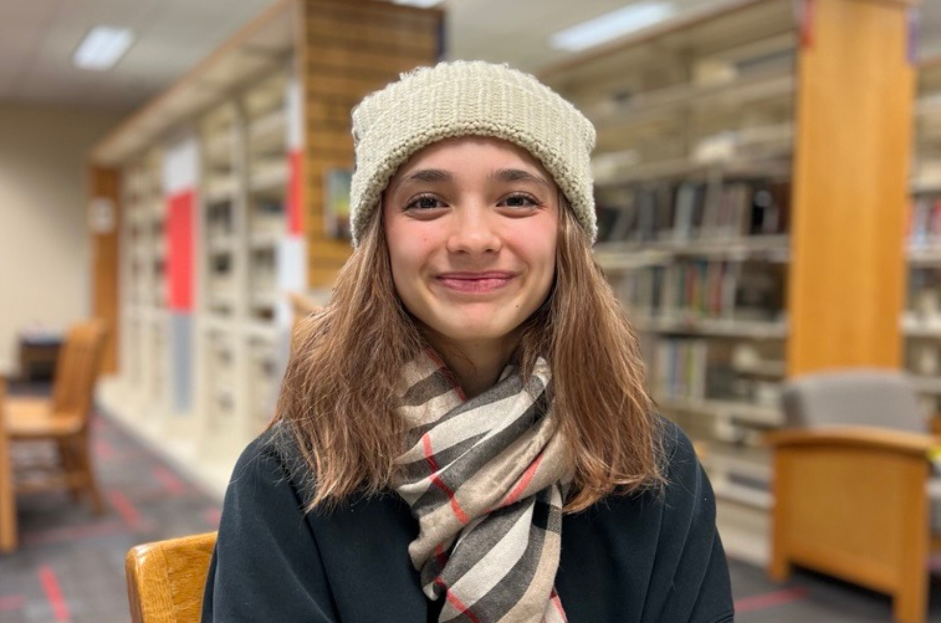 A portrait of Tasha sitting in the library at Renton High School.