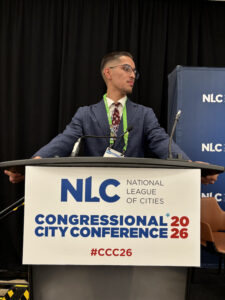 College Possible student poses behind a podium at the 2026 National League Of Cities Conference.