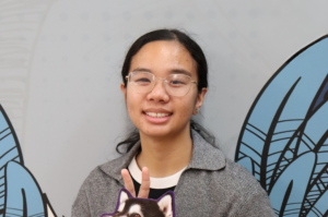 Scholarship recipient, Lana, holds a sign that says “Go Huskies!”