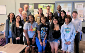 A large group of people pose together during a school visit at Franklin High School, including Tisha Held along with other staff, students, and event attendees.
