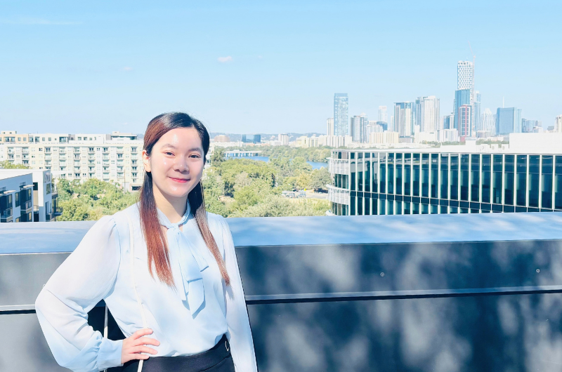 Maryrose standing on a balcony overlooking the Austin, Texas Skyline
